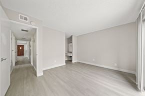 Anaheim apartment for rent - an empty living room and hallway with wood floors and white walls