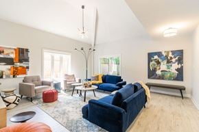 Ottawa apartment for rent - a living room with blue couches and chairs and a rug