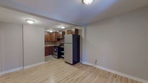 Ottawa apartment for rent - an empty living room with a refrigerator and a kitchen