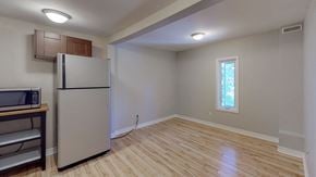 Ottawa apartment for rent - an empty living room with a refrigerator and a window
