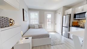 Ottawa apartment for rent - a bedroom with a bed and a refrigerator