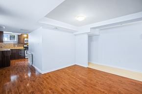 Ottawa apartment for rent - an empty living room and kitchen with wood floors and white walls