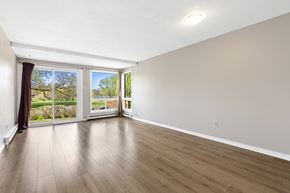 Ottawa condo for rent - an empty living room with wood flooring and sliding glass doors