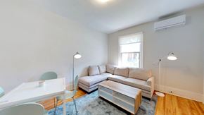 Ottawa apartment for rent - a living room with a couch and a desk and a window