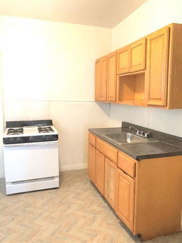 Philadelphia apartment for rent - A kitchen with a white stove and wooden cabinets.