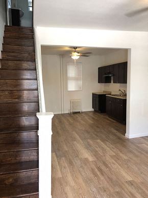 Philadelphia apartment for rent - A wooden staircase leads to a kitchen area.