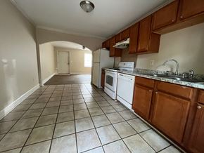 Atlanta apartment for rent - an empty kitchen with tile flooring and wooden cabinets