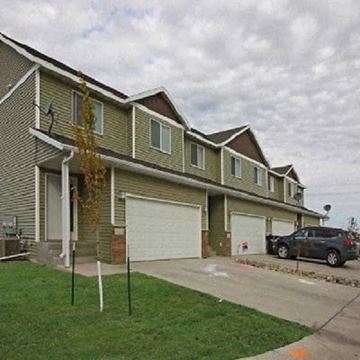 Fargo house for rent - A row of houses with a car parked in front of the first one.