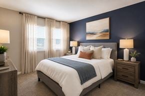Nashville apartment for rent - A bedroom with a large bed, a nightstand, and a painting on the wall.