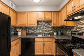 Nashville apartment for rent - A kitchen with wooden cabinets and black appliances.
