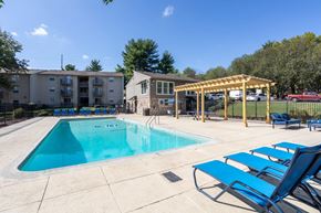 Nashville apartment for rent - A swimming pool with sun loungers and a building in the background.