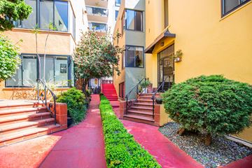 Oakland apartment for rent - A red pathway leads to a building with a glass door.