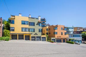 Oakland apartment for rent - A row of colorful buildings with the number 900 on the yellow one.