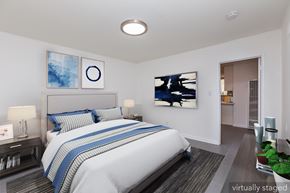 Oakland apartment for rent - A bedroom with a large bed and a painting on the wall.