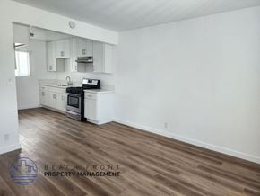 Lomita apartment for rent - A kitchen with white cabinets and a wooden floor.