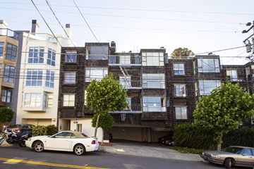 San Francisco apartment for rent - A white car is parked on the street in front of a building.