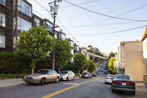 San Francisco apartment for rent - Cars are parked on a street with buildings on the side.