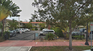 Miami Beach apartment for rent - A black gate blocks the road to a residential area.