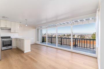 San Francisco apartment for rent - A kitchen with a stove top oven and a balcony with a railing.