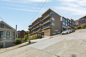 San Francisco apartment for rent - A car is parked in front of a building with a mural of fish on it.