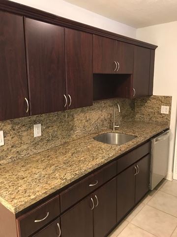 Tampa apartment for rent - A kitchen with brown cabinets and granite countertops.
