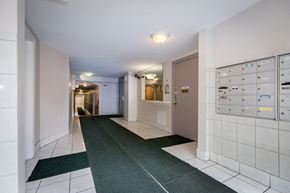 Chicago apartment for rent - a long hallway with tile floors and a locker room