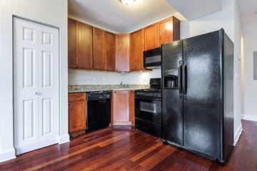 Chicago apartment for rent - a kitchen with black appliances and wooden cabinets