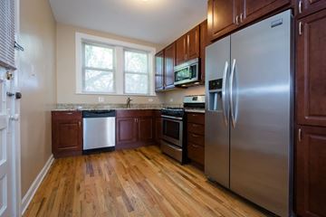 Chicago apartment for rent - a kitchen with stainless steel appliances and wooden floors