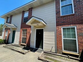 Baton Rouge house for rent - A house with a white garage door and a black door.
