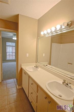 Baton Rouge house for rent - A bathroom with a sink, mirror, and lights.