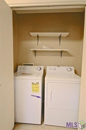 Baton Rouge house for rent - Two white front loading washing machines in a small laundry room.