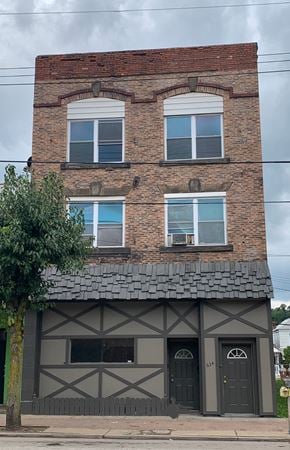 Glassport apartment for rent - A two-story building with a brick facade and a black and white timbered section.