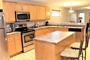 Brandon condo for rent - a kitchen with stainless steel appliances and wooden cabinets