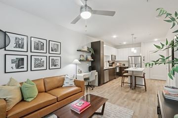 Nashville apartment for rent - A living room with a brown leather couch and a coffee table with a pink book on it.
