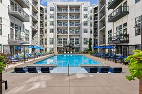 Nashville apartment for rent - A large swimming pool surrounded by lounge chairs and apartment buildings.