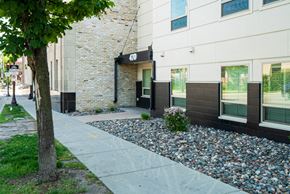 St Paul apartment for rent - A white building with a black awning and a tree in front of it.