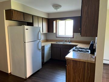 Oak Forest apartment for rent - A white refrigerator is in a kitchen with wooden cabinets.