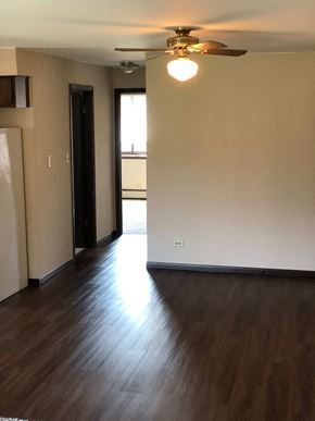Oak Forest apartment for rent - A room with a ceiling fan and wooden flooring.