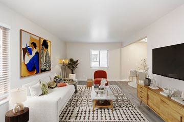 Oakland apartment for rent - A living room with a white couch, a coffee table, and a painting on the wall.