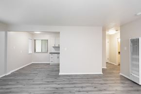 Oakland apartment for rent - A spacious, empty room with wooden flooring and white walls.