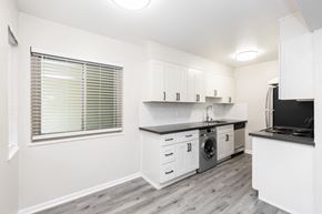Oakland apartment for rent - A kitchen with white cabinets and a black countertop.