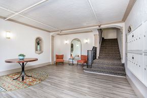 Oakland apartment for rent - A hallway with a staircase, a table, and chairs.