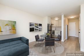 Oakland apartment for rent - A living room with a grey couch and a glass table with chairs.