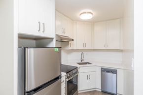 Oakland apartment for rent - A kitchen with white cabinets and a stainless steel refrigerator.
