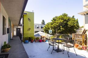Oakland apartment for rent - A patio with a table and chairs and a green tree.
