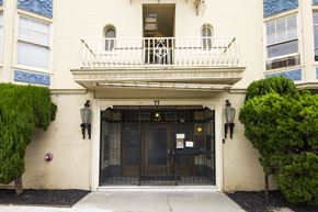 Oakland apartment for rent - A white building with a black gate and a balcony.