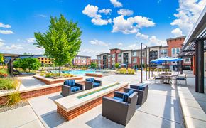 Westminster apartment for rent - an outdoor patio with lounge chairs and a pool at the residences at town center apartments
