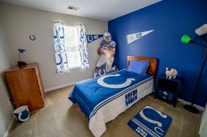 Anderson apartment for rent - a boy bedroom with a bed and a blue wall and a baseball player