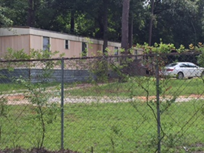 Jackson house for rent - A white car is parked behind a chain link fence.