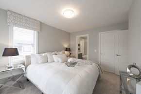 Edmonton townhouse for rent - a bedroom with a large white bed and a closet